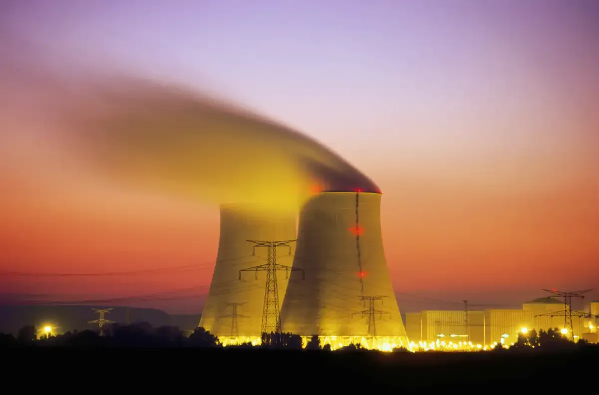 Illustration of a nuclear power facility connected to electricity transmission lines