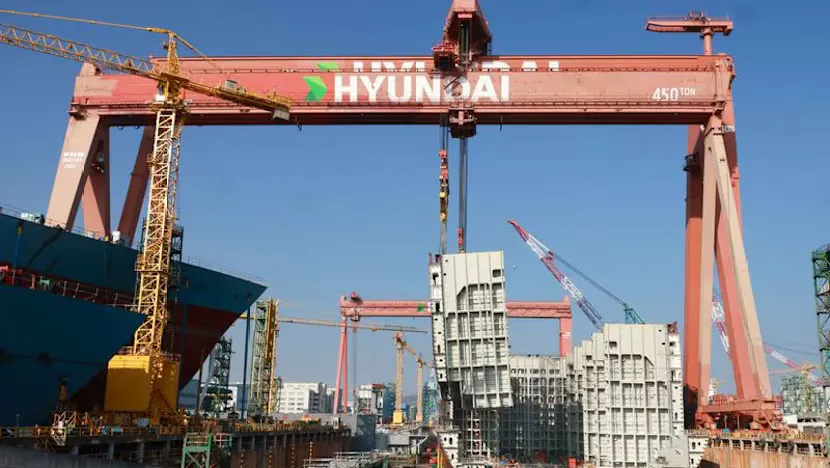 Shipyard cranes beside vessels under construction
