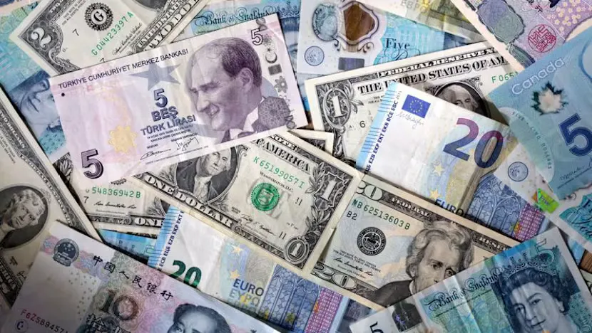 Currency trading screens alongside U.S. government bond yield charts