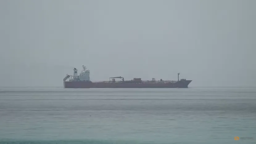 Oil tanker at a terminal with fuel storage tanks in the background